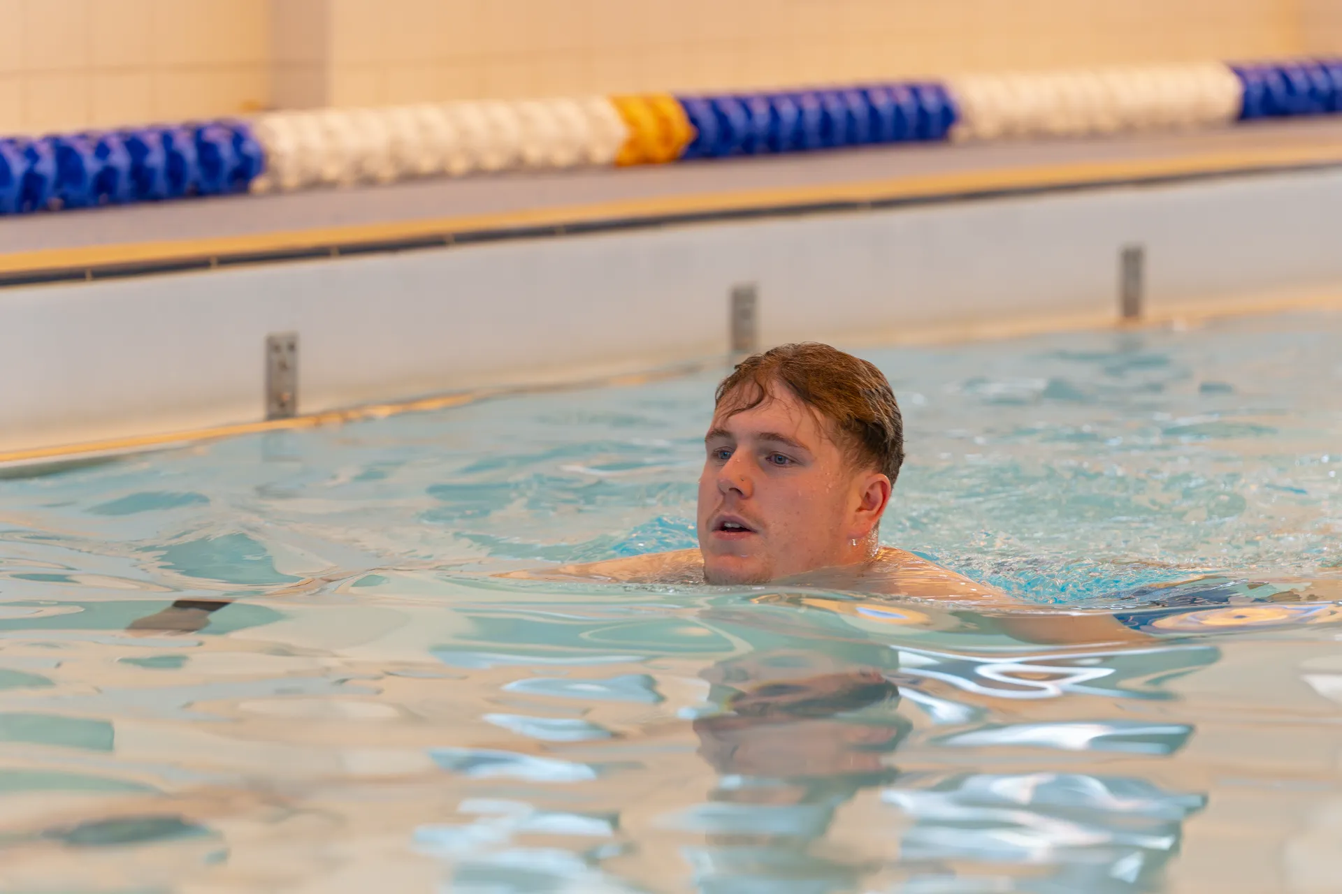 Man in swmming pool lane swimming