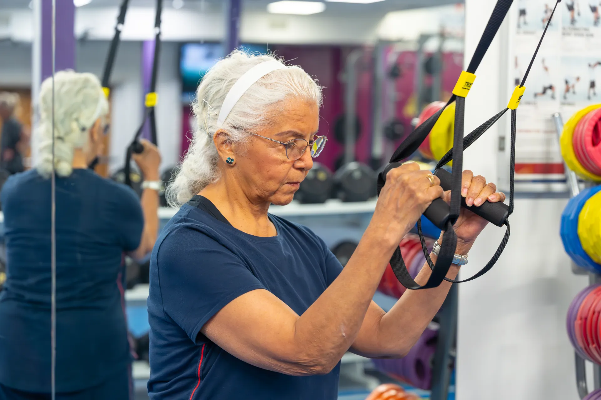 Senior woman in a functional fitness class, using a TRX machine